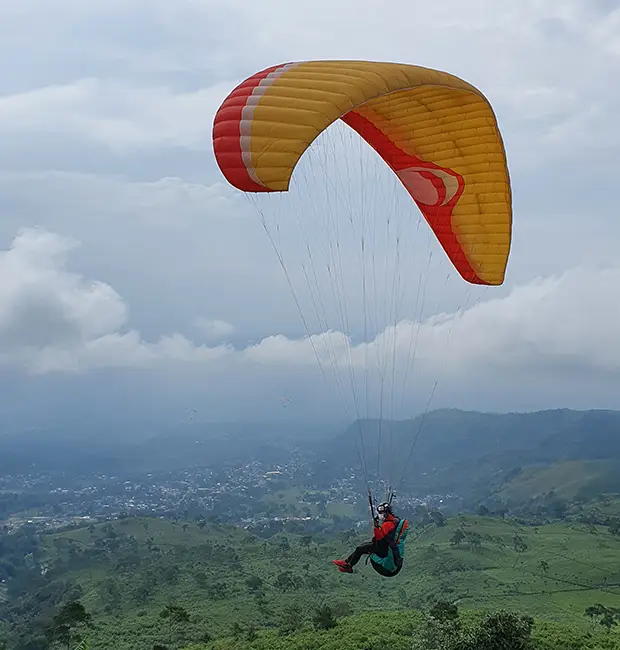 Paraglider flying over hills